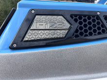 Load image into Gallery viewer, Close-up of a vehicle grille with &#39;F123&#39; branding on a blue and gray background.
